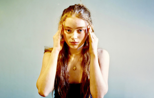 Рыжеволосая американская актриса Сэди Синк на сером фоне