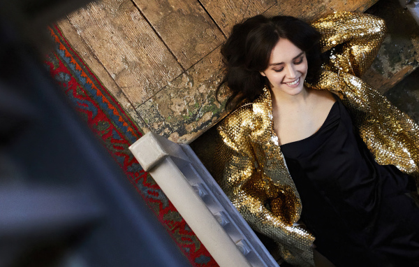 Улыбающаяся актриса Оливия Кук в черном платье