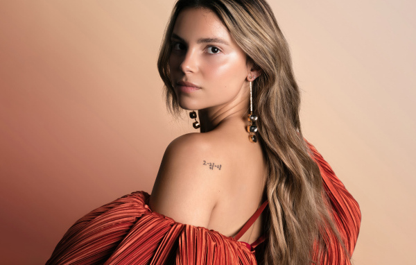 Стильная девушка актриса Инде Наварретт на розовом фоне