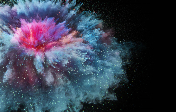 Взрыв разноцветной порошковой краски на черном фоне