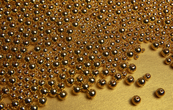 Много золотых бусин на желтом фоне