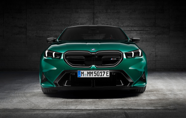 Зеленый автомобиль BMW M5 2024  года вид спереди