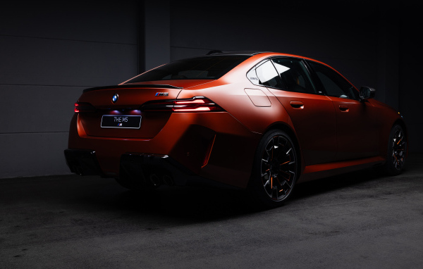Вид сзади на красный автомобиль BMW M5 2025 года
