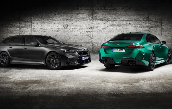 Два автомобиля BMW M5 2024 года на фоне серой стены