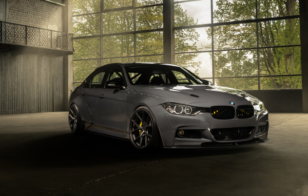 Белый автомобиль BMW F30 Widebody в здании