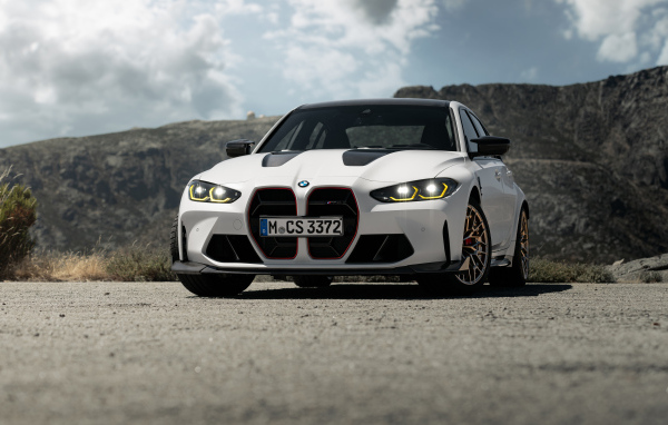 Белый автомобиль BMW M3 CS  на фоне гор