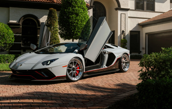 Серый автомобиль Lamborghini Aventador с открытыми дверями
