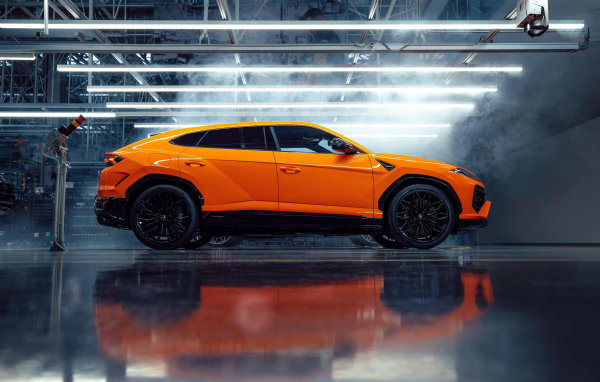 Оранжевый автомобиль Lamborghini Urus SE Plug-In Hybrid Super SUV вид сбоку