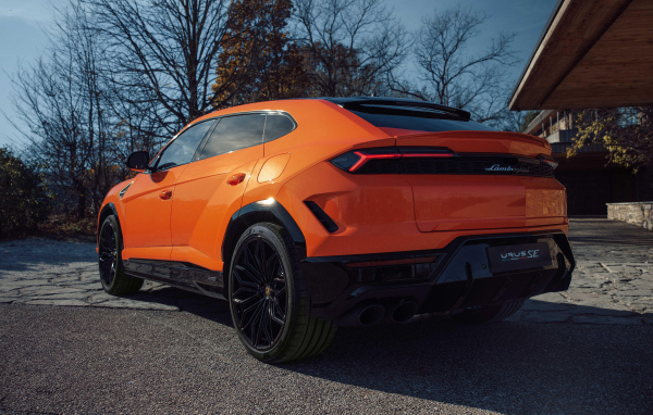 Вид сзади на оранжевый внедорожник Lamborghini Urus SE Plug-In Hybrid