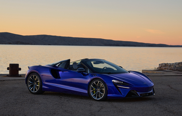 Синий быстрый автомобиль McLaren Artura Spider у воды