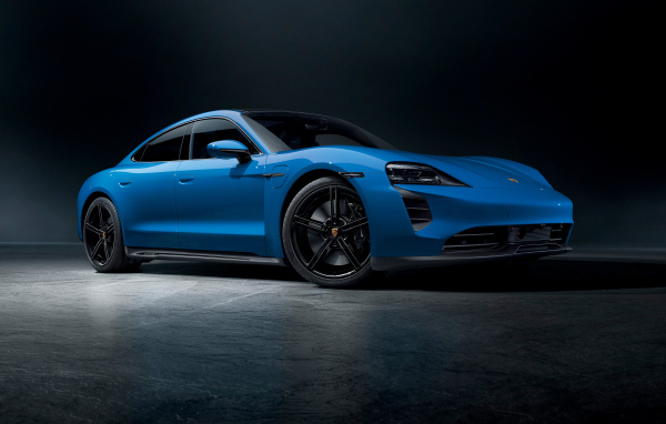 Синий автомобиль Porsche Taycan GTS на черном фоне