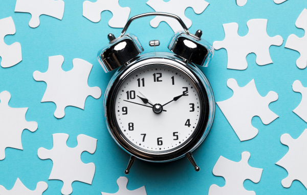 Будильник на голубом фоне с пазлами