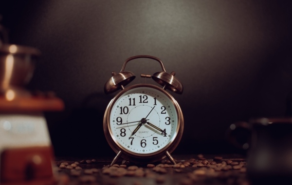 Будильник на столе с зернами кофе