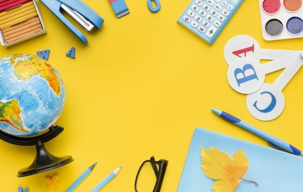 Красивые канцелярские предметы и глобус на желтом фоне