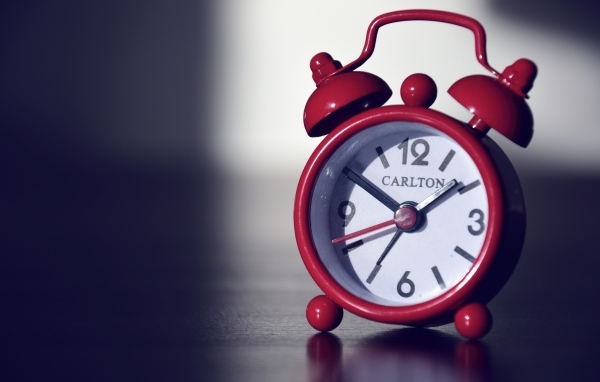 Красный будильник на черном столе