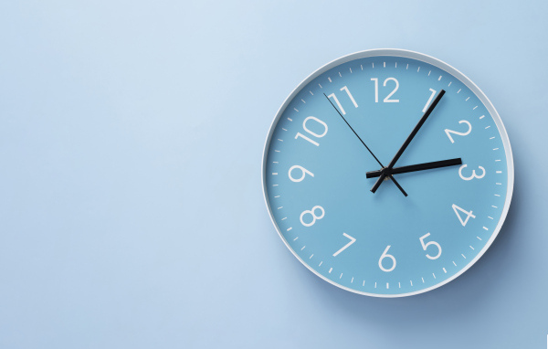 Круглые часы на голубом фоне крупным планом