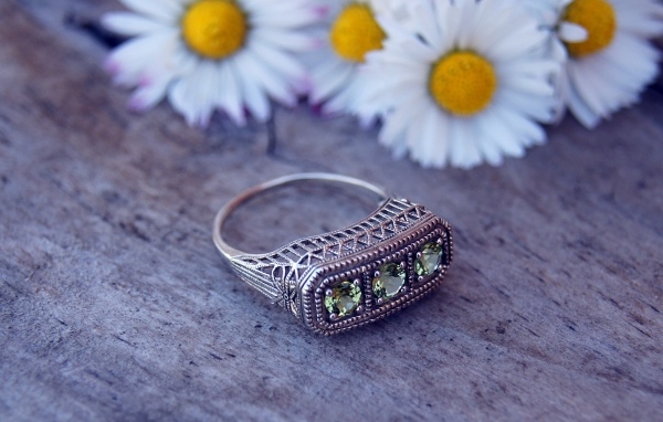 Старинный перстень на столе с ромашками