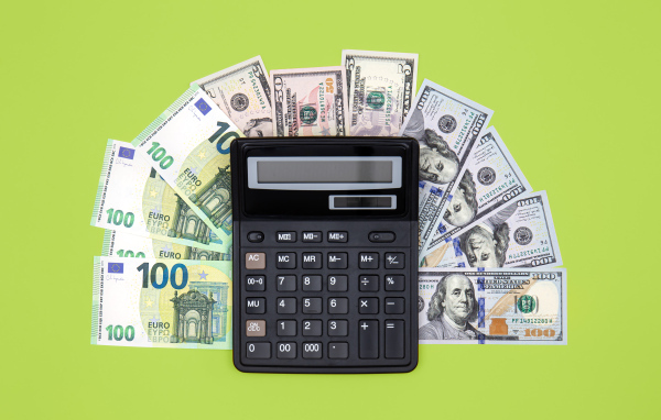 Калькулятор и доллары на зеленом фоне