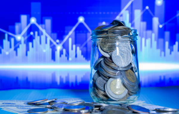 Банка с монетами на фоне таблицы