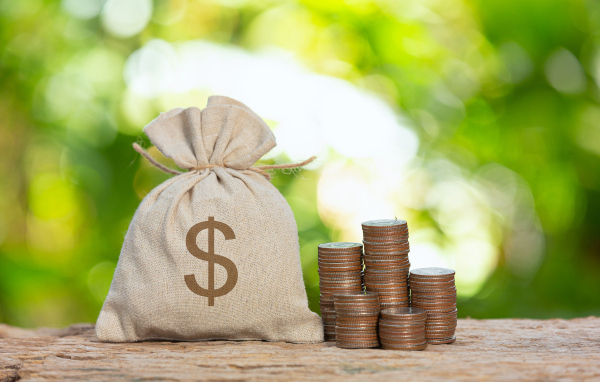 Мешок с деньгами на столе с монетами