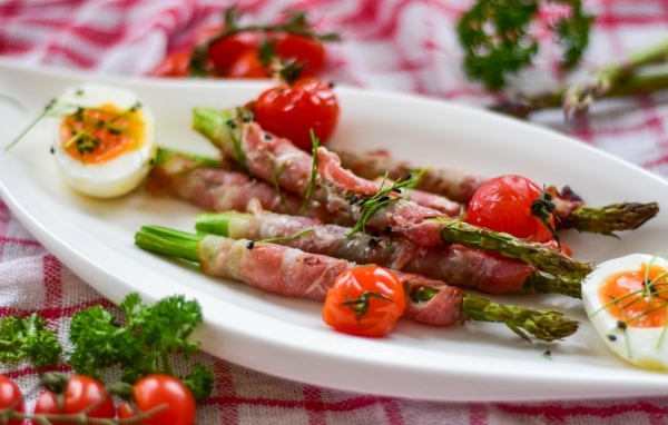 Спаржа в беконе на тарелке с вареными яйцами