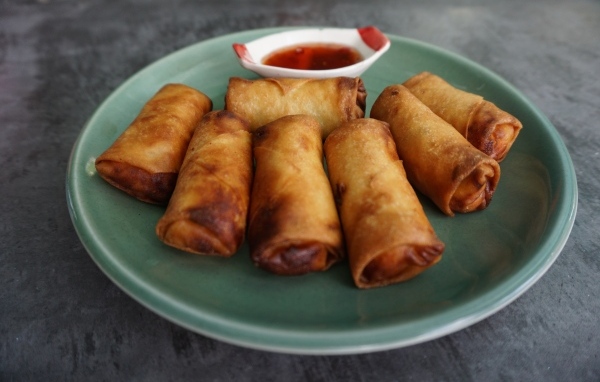 Яичные рулетики на большой тарелке с соусом