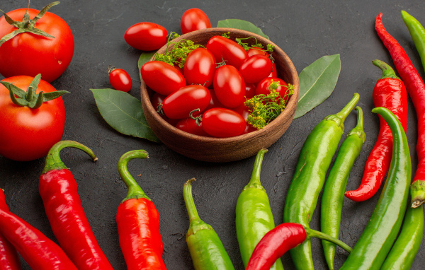 Свежие помидоры на столе с острым перцем