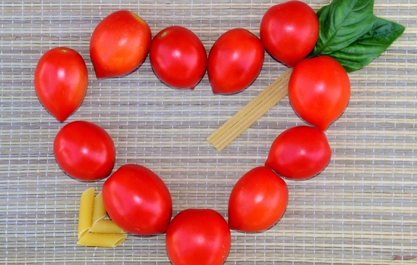 Сердце из помидоров на столе с макаронами