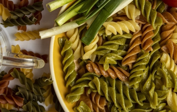 Разноцветные сваренные макароны с зеленым луком