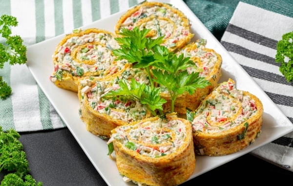 Рулет с омлета с начинкой на тарелке