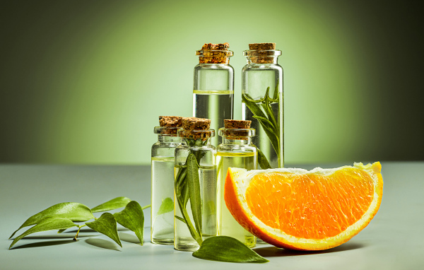 Апельсиновое масло на зеленом фоне с апельсинами