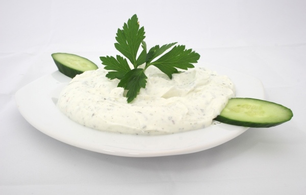 Соус на тарелке со свежими огурцами