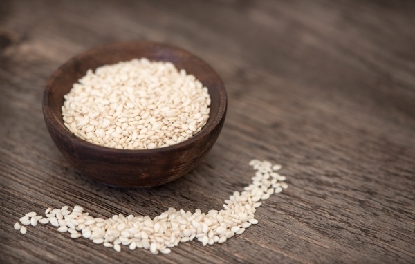 Зерна кунжута в деревянной миске на столе