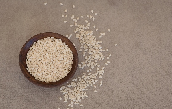 Зерна кунжута в деревянной миске на столе