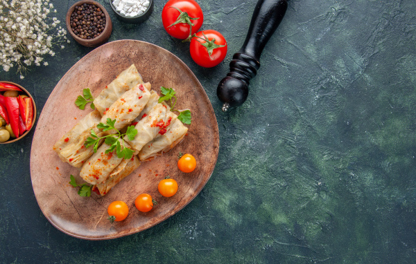 Голубцы на столе с помидорами и специями