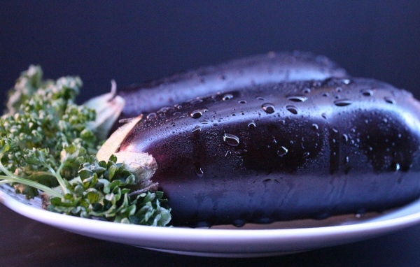 Два баклажана на тарелке с зеленью