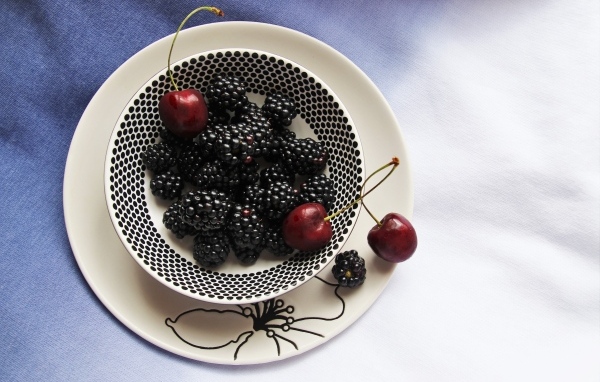 Ягоды ежевики и черешни на столе