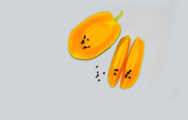 Разрезанная папайя на сером фоне