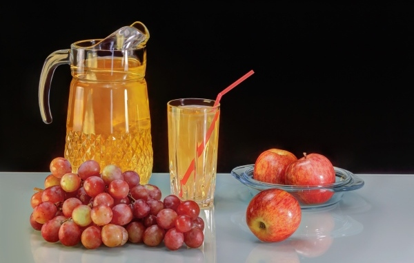 Виноград и яблоки на столе с соком