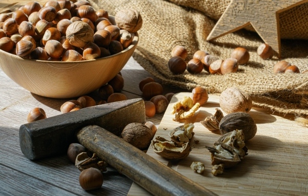 Фундук и грецкие орехи на столе с молотком