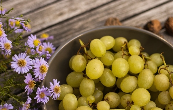 Белый виноград в миске с цветами