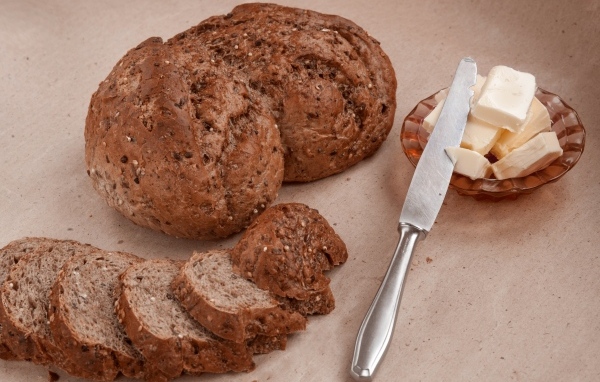 Ржаной хлеб со сливочным маслом и ножом на столе