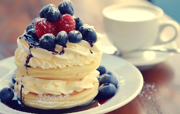 Сырники с кремом и ягодами на столе на завтрак