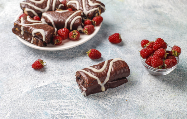 Шоколадные рулетики с ягодами малины на столе