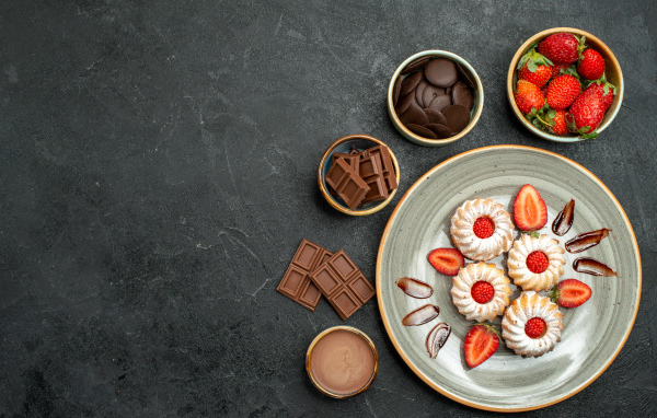 Печенье на столе с шоколадом и ягодами клубники