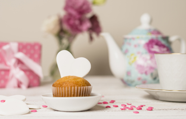 Кекс с сердечком на столе с посудой