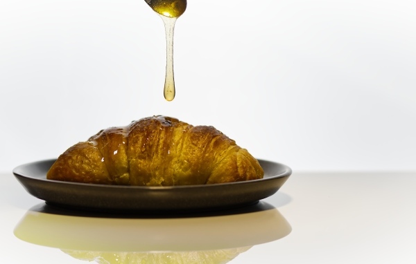 Свежий круассан с медом на завтрак