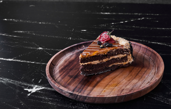 Большой кусок торта на деревянной доске