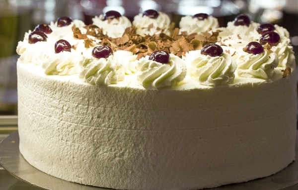 Большой белый торт с ягодами вишни