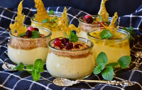 Лимонный крем с ягодами в баночках на столе